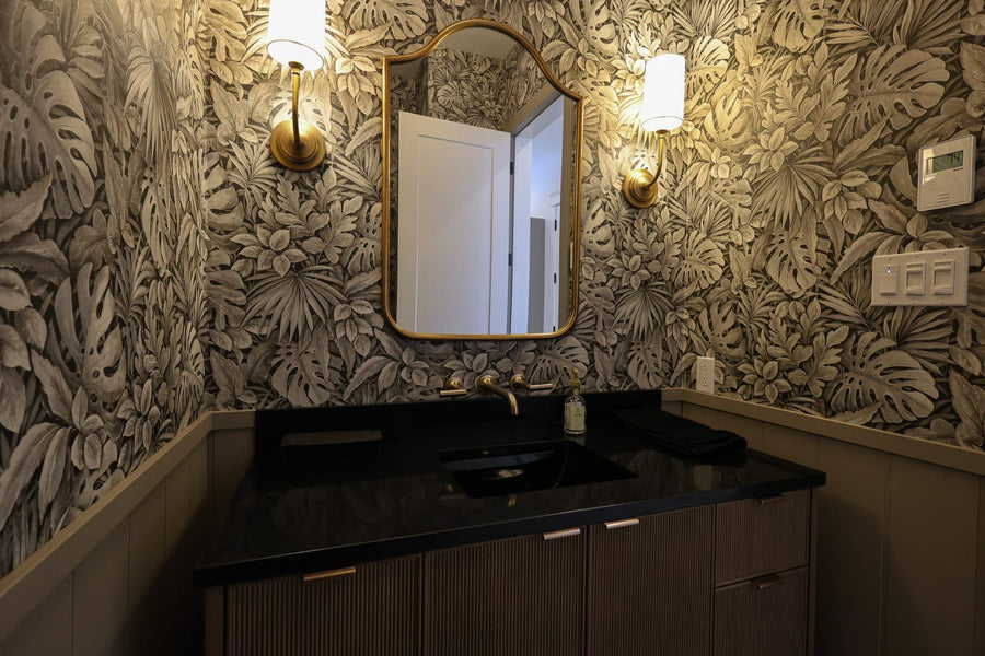 A powder room in St-Zotique dressed in wallpaper, turning a small space into a refined, characterful room.